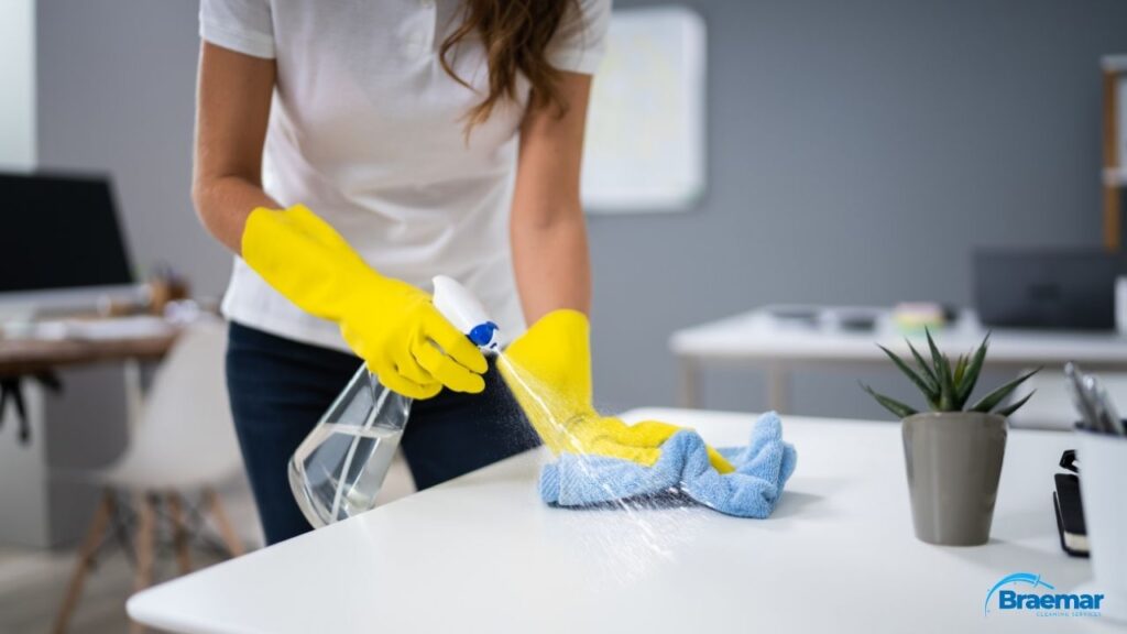 Braemar cleaner sanitising an office desk in Edinburgh