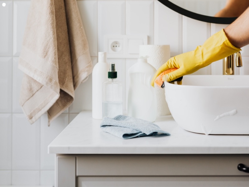 Cleaner wiping a bathroom vanity during a regular clean