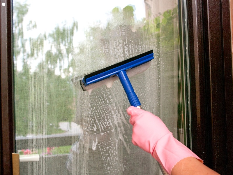 Squeegee cleaning a soapy window pane
